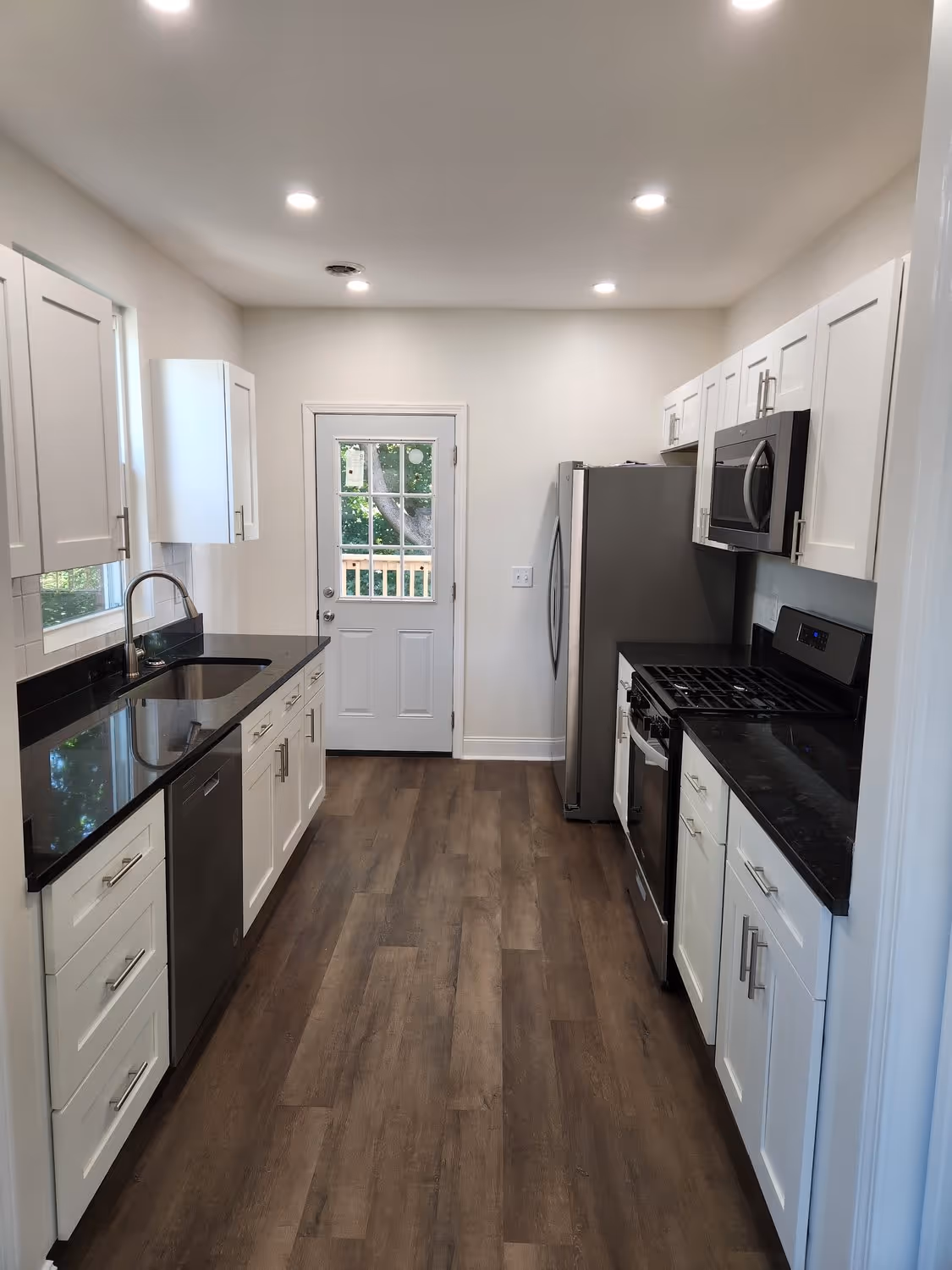 The finished kitchen at 438 N. Fairmount, white cabinets, dark counters, and a new back door