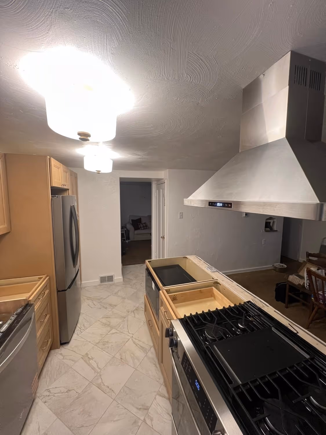 The finished kitchen at Bower Hill, new cabinets, range hood, and appliances, lights on